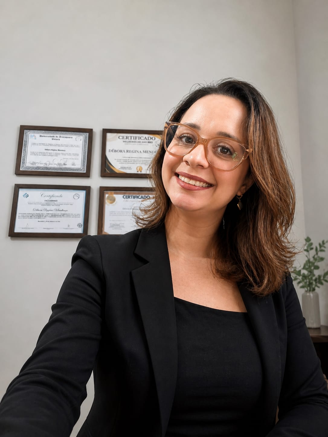 Débora Mendonça, neuropsicóloga em Araraquara, com certificados ao fundo
